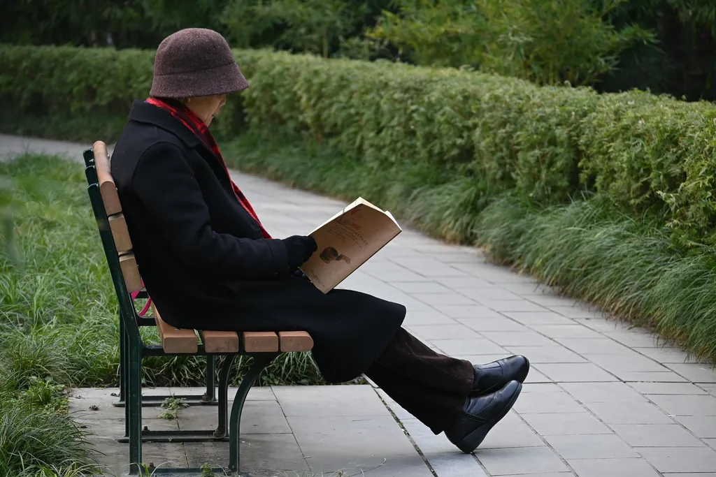 Älterer Mensch liest ein Buch auf einer Parkbank – Entlastungsbetrag richtig nutzen: Beispiele aus der Praxis