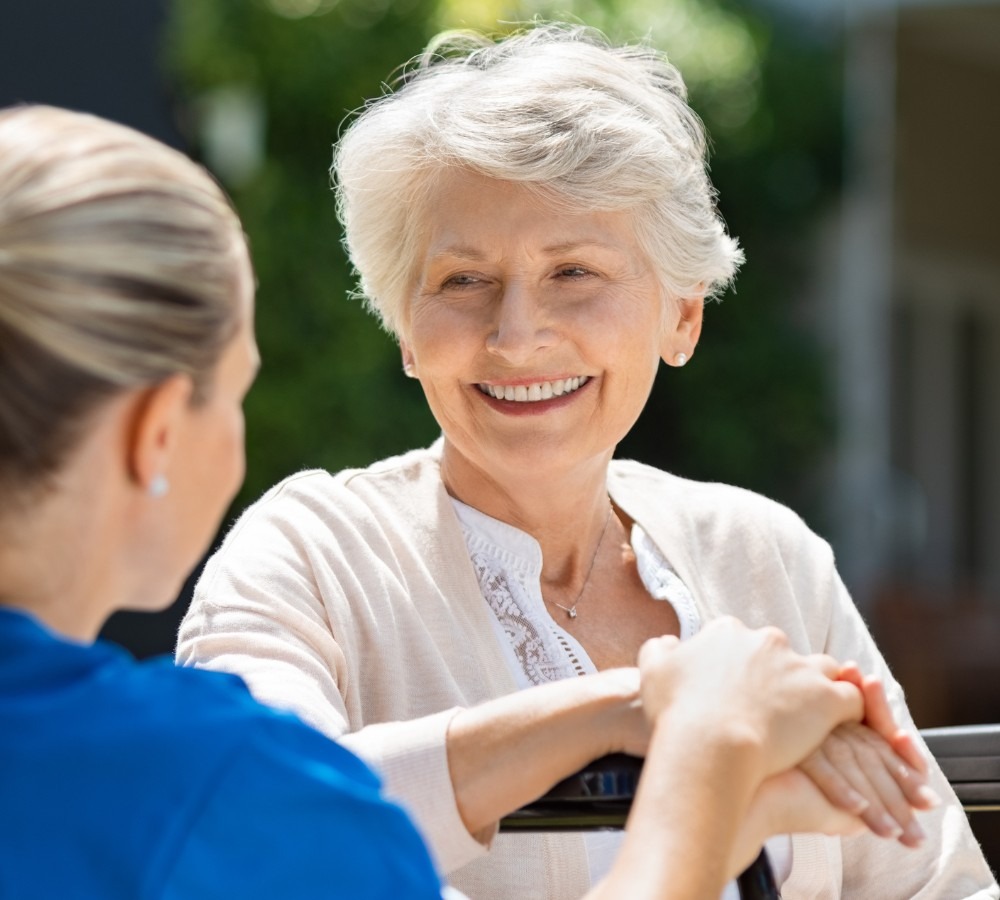 Frau lacht ihre Pflegekraft an. Pflegedienst Hamburg Pflegedienst Helfende Hände